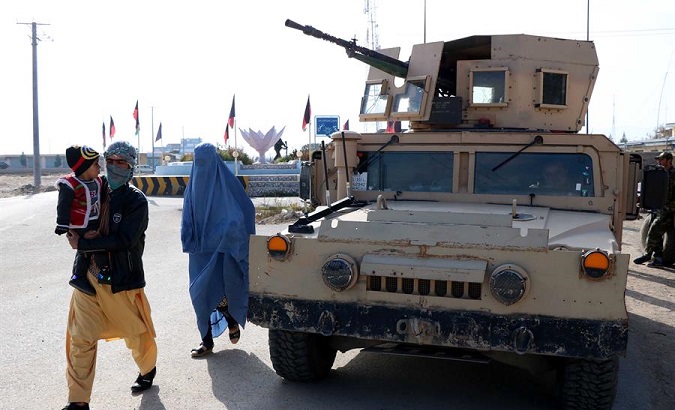 A family walking by a military vehicle in Herat, Afghanistan, Nov. 28, 2020.