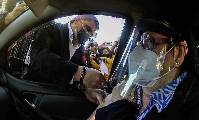 Health Minister Julio Borba vaccinates a citizen in Asuncion, Paraguay, March 2021.