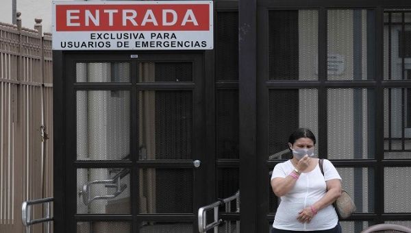 A woman waits at the entrance of a hospital in San Jose, Costa Rica, Apr. 30, 2021.