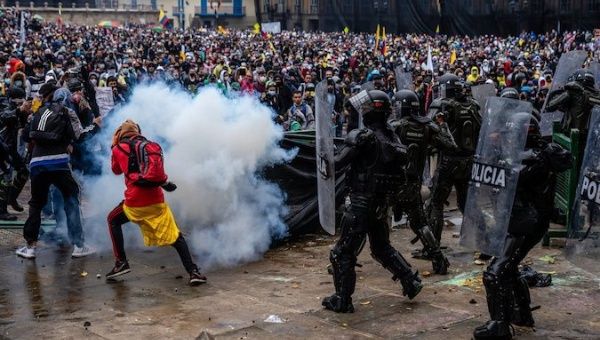 Police officers shoot at demonstrators in Bogota, Colombia, May 2021.
