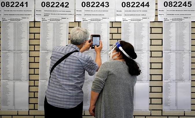 A Peruvian citizen consults voters lists at a polling station in Tokyo, Japan, Jun. 6, 2021.