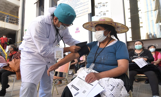 A woman receives medical attention before receiving a COVID-19 vaccine, Cochabamba, Bolivia, Jun. 7, 2021.