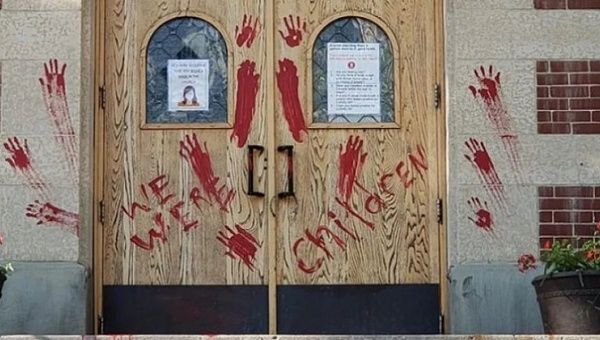 A Roman Catholic church in downtown Saskatoon is painted with blood looking hands in Canada on June 25, 2021.