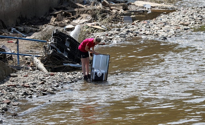A resident cleans furniture after a flood, Pepinster, Belgium, July 20, 2021.