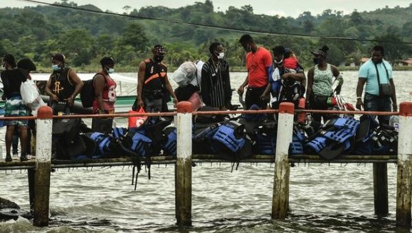 Stranded migrants from Haiti and several African countries are seen before boarding a boat at a pier in Necocli, Colombia, to cross into neighboring Panama on their way to the United States.