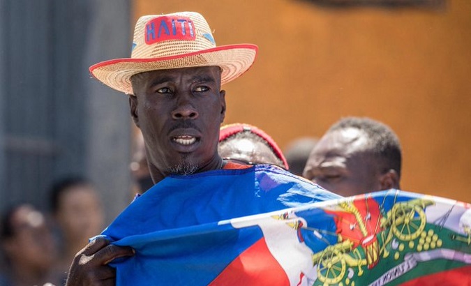 Citizen holds the Haitian flag.
