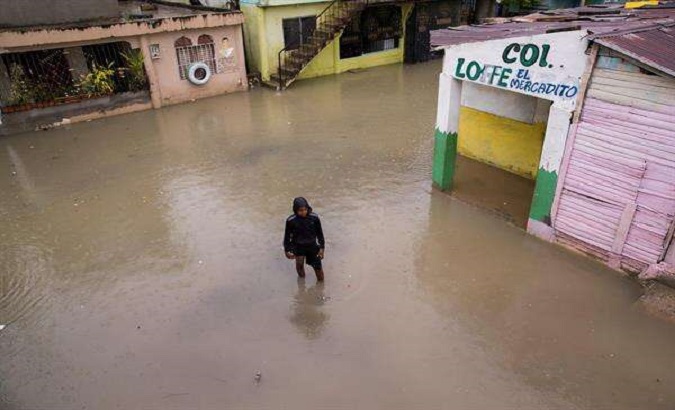 A young man walks through flooded streets in San Cristobal, Puerto Rico, Aug. 13, 2021.