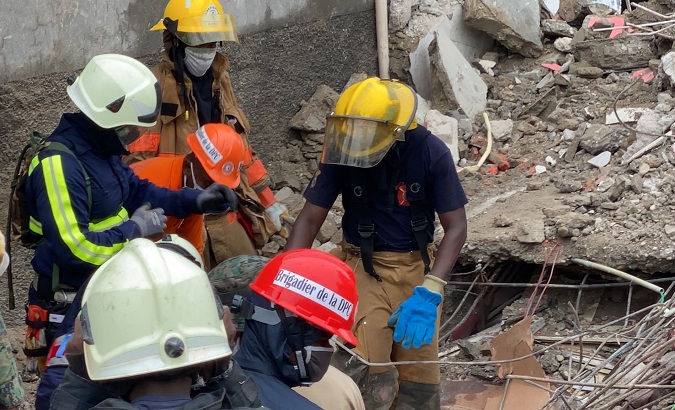 Civil defense rescuers search for earthquake survivors, Haiti, Aug. 17 2021.