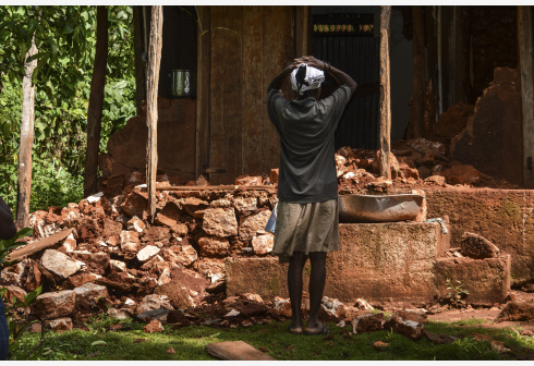 A man stands in front of a damaged house in Pestel, Haiti, Aug. 18, 2021.