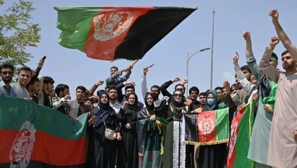 Citizens wave the flag of the Republic of Afghanistan, Aug. 19, 2021.