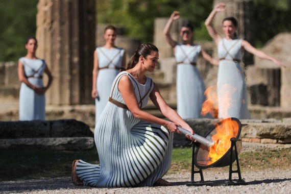 Greek actress Xanthi Georgiou, playing the role of an ancient Greek High Priestess, lights the torch during the Olympic flame lighting ceremony for the Beijing 2022 Winter Olympic Games, in ancient Olympia, Greece, Oct. 18, 2021.