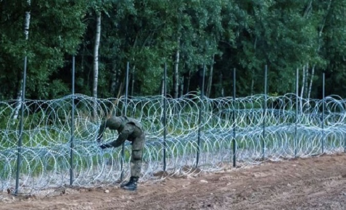 Polish military inspects barbed wire wall on Belarus border, Oct. 2021.