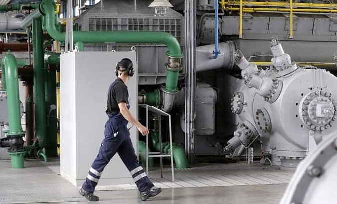 A man walks through a gas production plant.