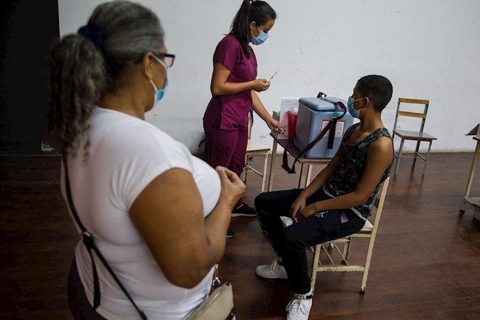 Minors attend a vaccination center in a school, today in Caracas (Venezuela).