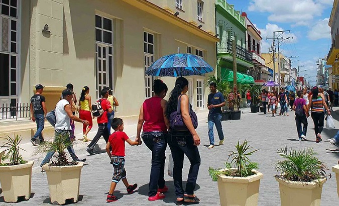Citizens walk down a boulevard, Camaguey, Cuba.