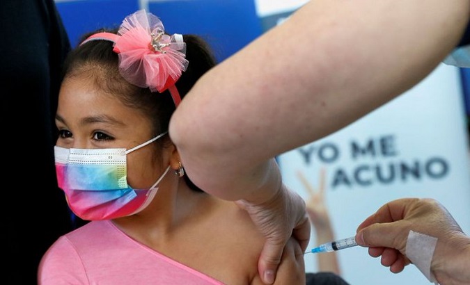 A girl gets a COVID-19 vaccine, Brazil, 2021.