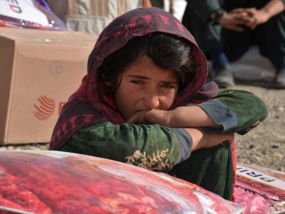An Afghan girl sits beside relief supplies in Khost province, east Afghanistan, Nov. 9, 2021.