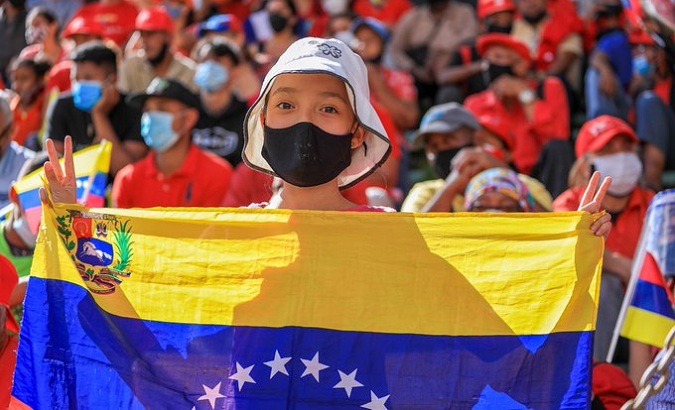 A girl holding the flag of Venezuela, 2021.