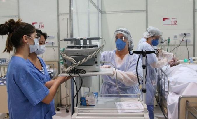 Brazilian health professionals attend to a COVID-19 patient in an intensive care unit, Feb. 2022.