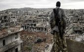 A soldier contemplates the ruins of a neighborhood bombed during the 2011 NATO intervention in Lybia.
