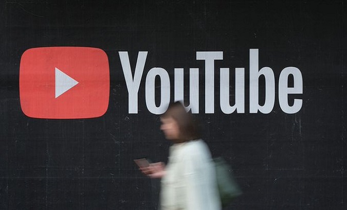 A woman walks past a billboard advertisement for YouTube.