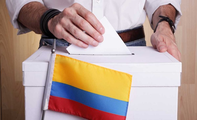 A Colombian citizen enter his ballot at a voting booth.