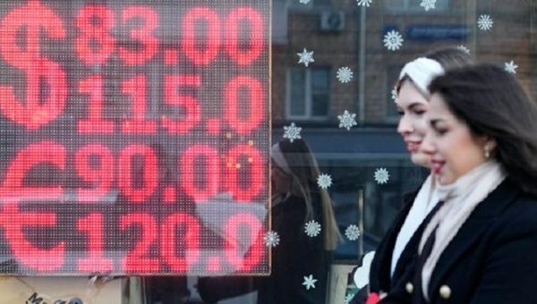 Russian women pass in front of a currency exchange house.