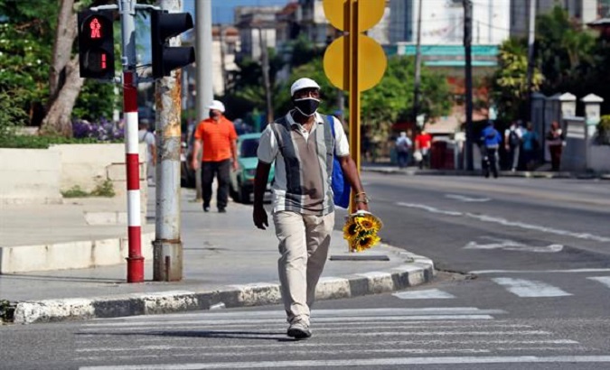 A citizen walks down a street with a mask, Havana, Cuba.