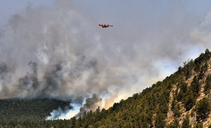 Firefighter plane flies over wildfire zone, U.S., 2022.