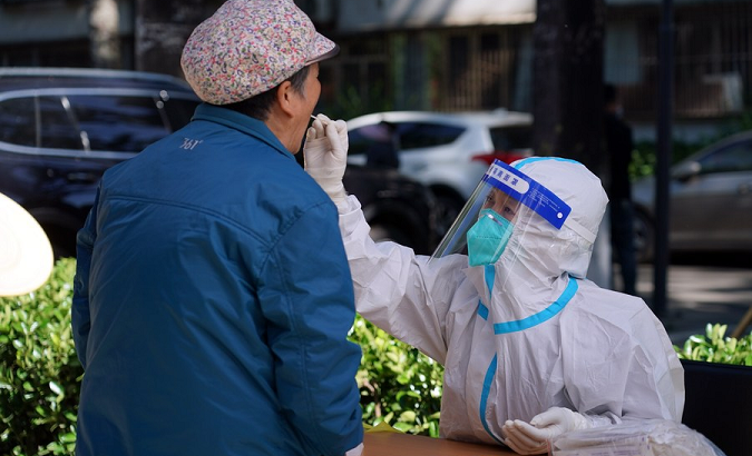 A medic takes a swab sample from a resident for nucleic acid test, Beijing, China, May 13, 2022.