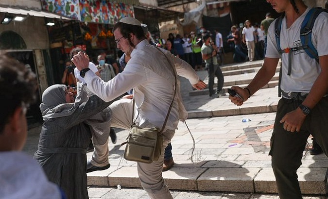 Far-right Israeli attacks an elderly Palestinian woman during the march of the flags, Old City, May 29, 2022.