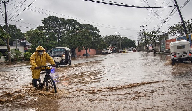 Citizens pass through a street flooded by storm Agatha rains, Mexico, May 2022.