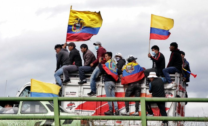 Members of the Indigenous communities carry Ecuadorian flags as they head towards Quito, June 20, 2022.