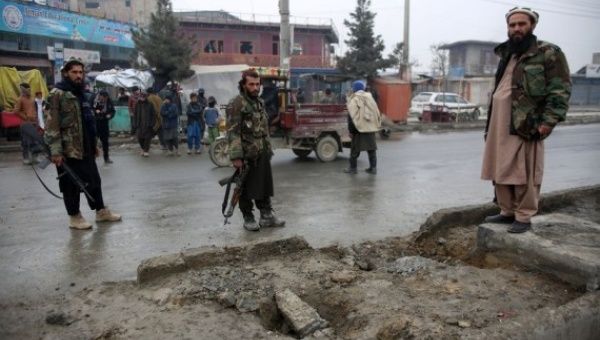 Taliban members inspect the site of a roadside bomb blast in Kabul, Afghanistan, on Jan. 16, 2022.