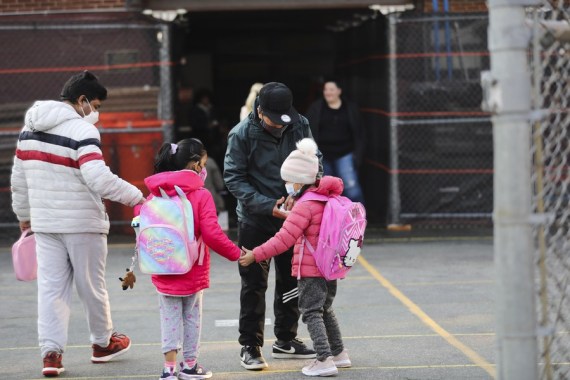 Children greet each other as they arrive at school in New York, the United States, March 7, 2022.