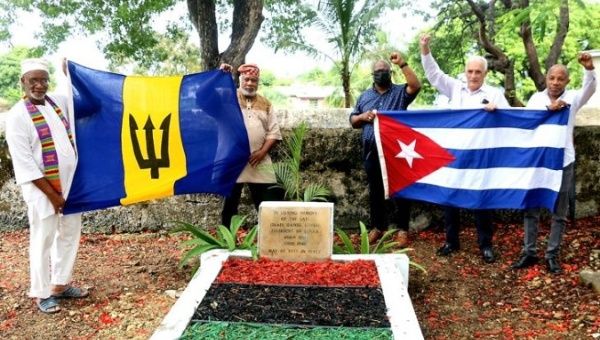 Activists raising the Cuban and Barbados flag over Israel Lovell's grave, July 26, 2022.