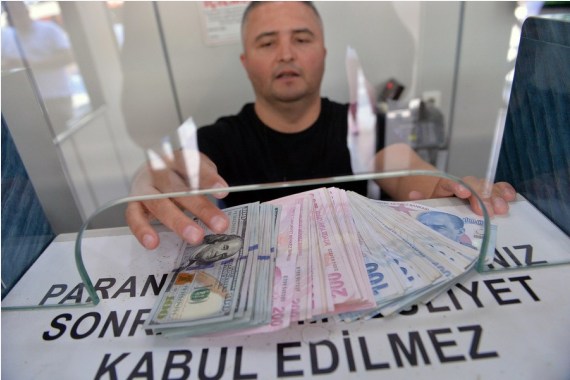 A teller displays cash at an exchange office in Ankara, Türkiye, on August 2, 2022.