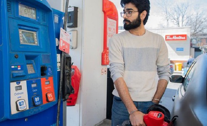 A man looks at the price of fuel, 2022.