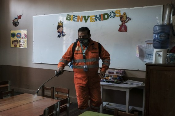 A City Hall worker disinfects a classroom at the Macaria Pinilla School on July 27, 2022, before students return to in-person classes in La Paz, Bolivia.