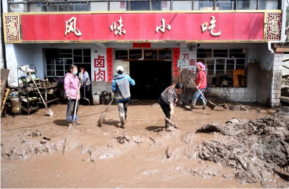 Local residents remove sludge off their property in Qingshan Township of Datong Hui and Tu Autonomous County in northwest China's Qinghai Province, Aug. 18, 2022.