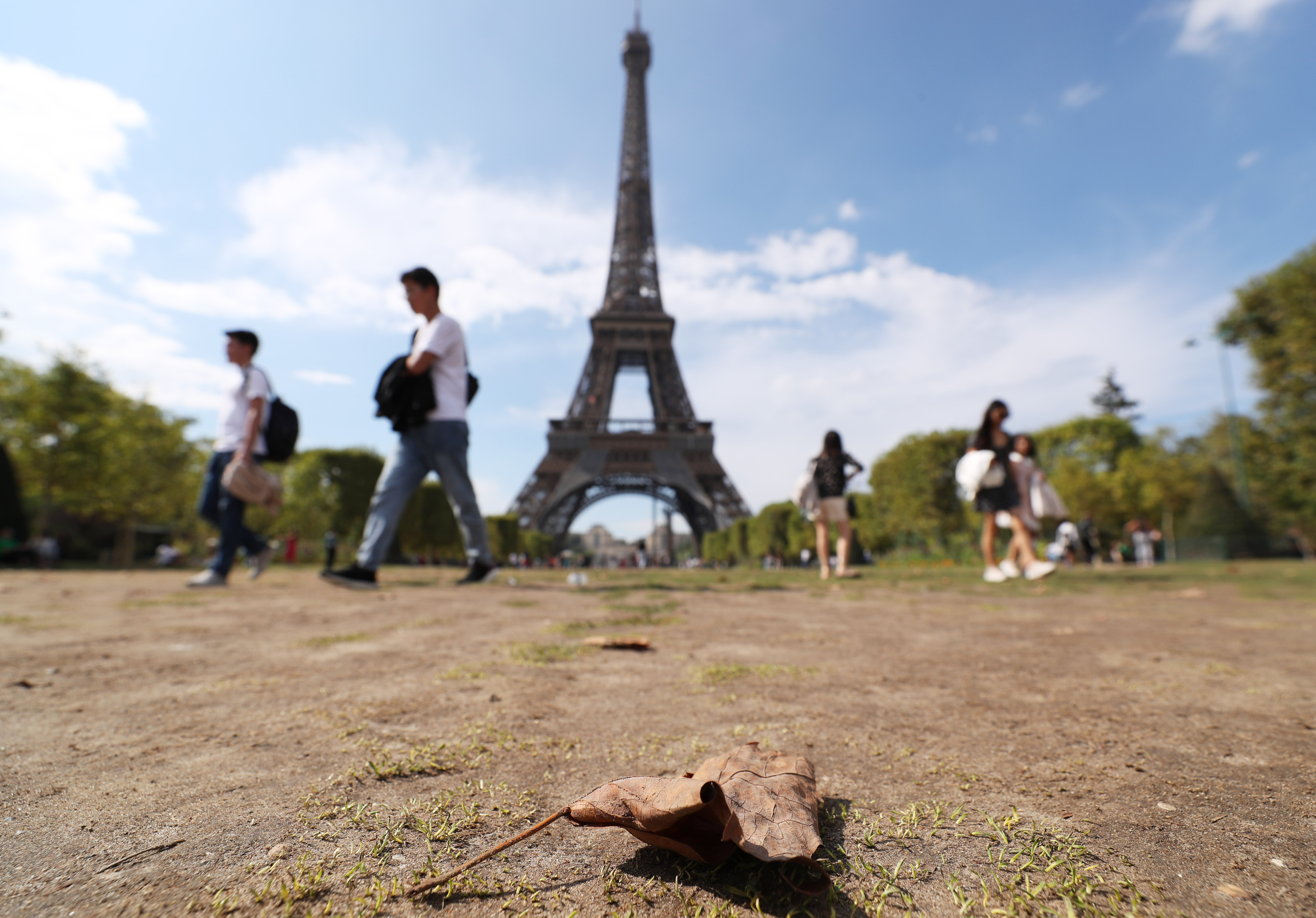 People walk on the Champ de Mars in front of the Eiffel tower in Paris, France, Aug. 17, 2022. As France is suffering a severe drought, water restriction measures have been imposed across the country.