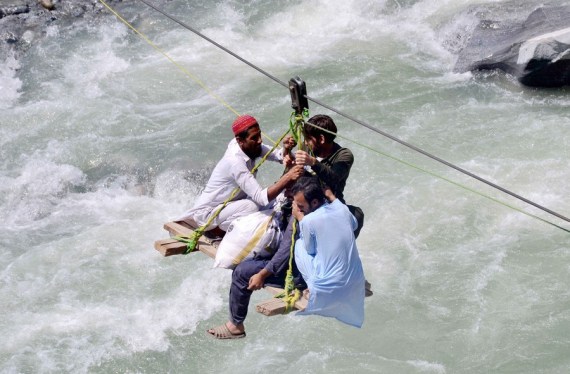 Local residents use a temporary cradle service to cross the river Swat after flash floods in Bahrain area of northwest Pakistan's Swat district on Sept. 5, 2022.