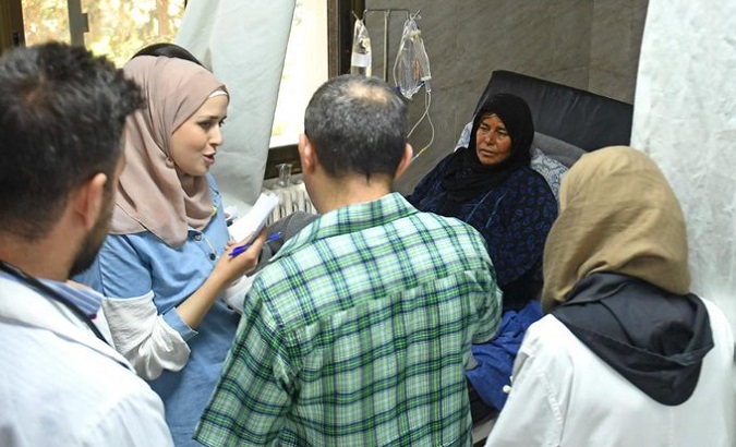 Doctor talks with the relatives of a cholera patient, Syria, 2022.