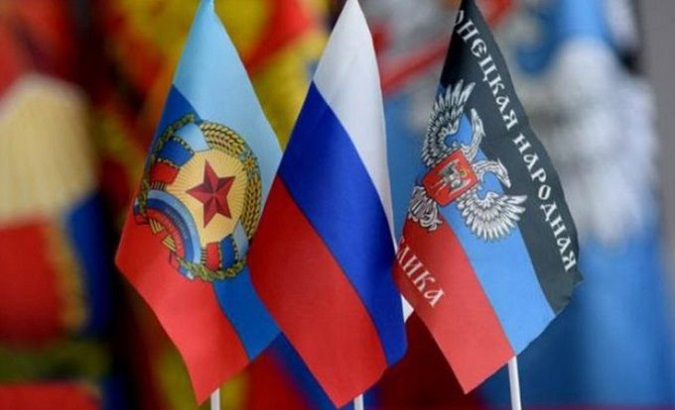 Russian flag in the center of the Donetsk and Luhansk flags.