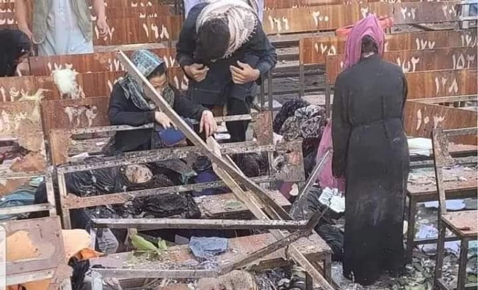 Women search for their children in the rubble of the destroyed school, Kabul, Afghanistan, Sept. 30, 2022.