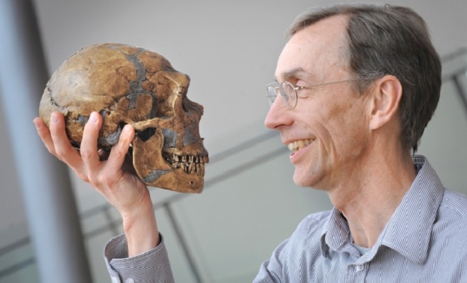 Scientist Svante Paabo holding a neanderthal skull, 2022.