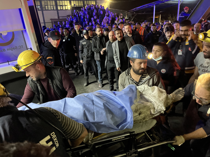 Paramedics and mine workers carry a wounded mine worker to an ambulance at the explosion site after an explosion occurred at a coal mine in Bartin, Turkey, 14 October 2022.