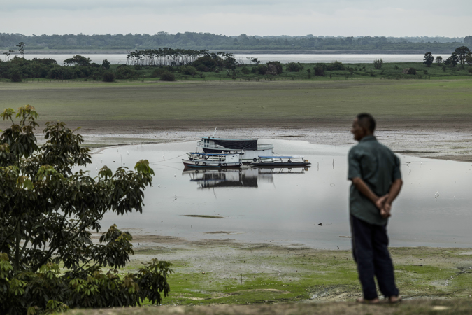 Fisherman Manoel Andrade de Araújo, 73, observes his boat stuck in the low waters of Lago do Aleixo affected by drought, on October 25, 2022, in the Amazon , in Manaus (Brazil)
