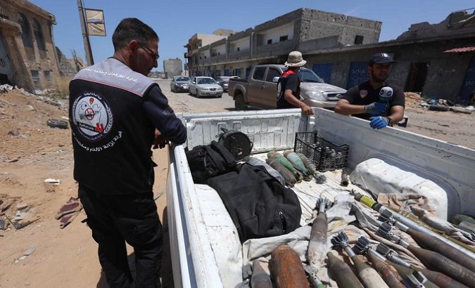 People picking up unexploded ordnance in Libya.