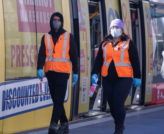 People wearing face masks walk in tram station in Sydney, Australia, on July 27, 2022.